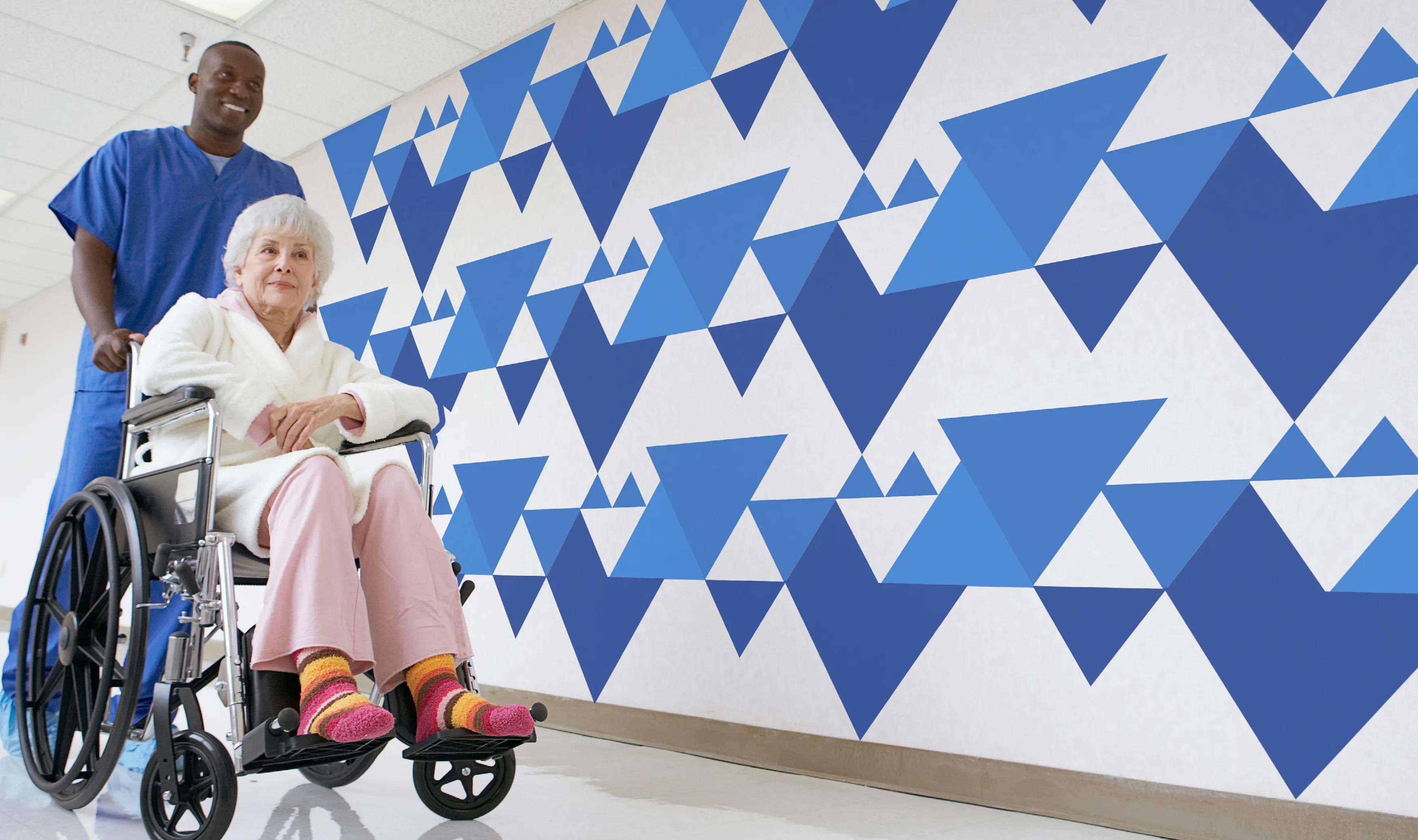 Nurse taking a patient on a wheelchair with the pattern displayed on the wall