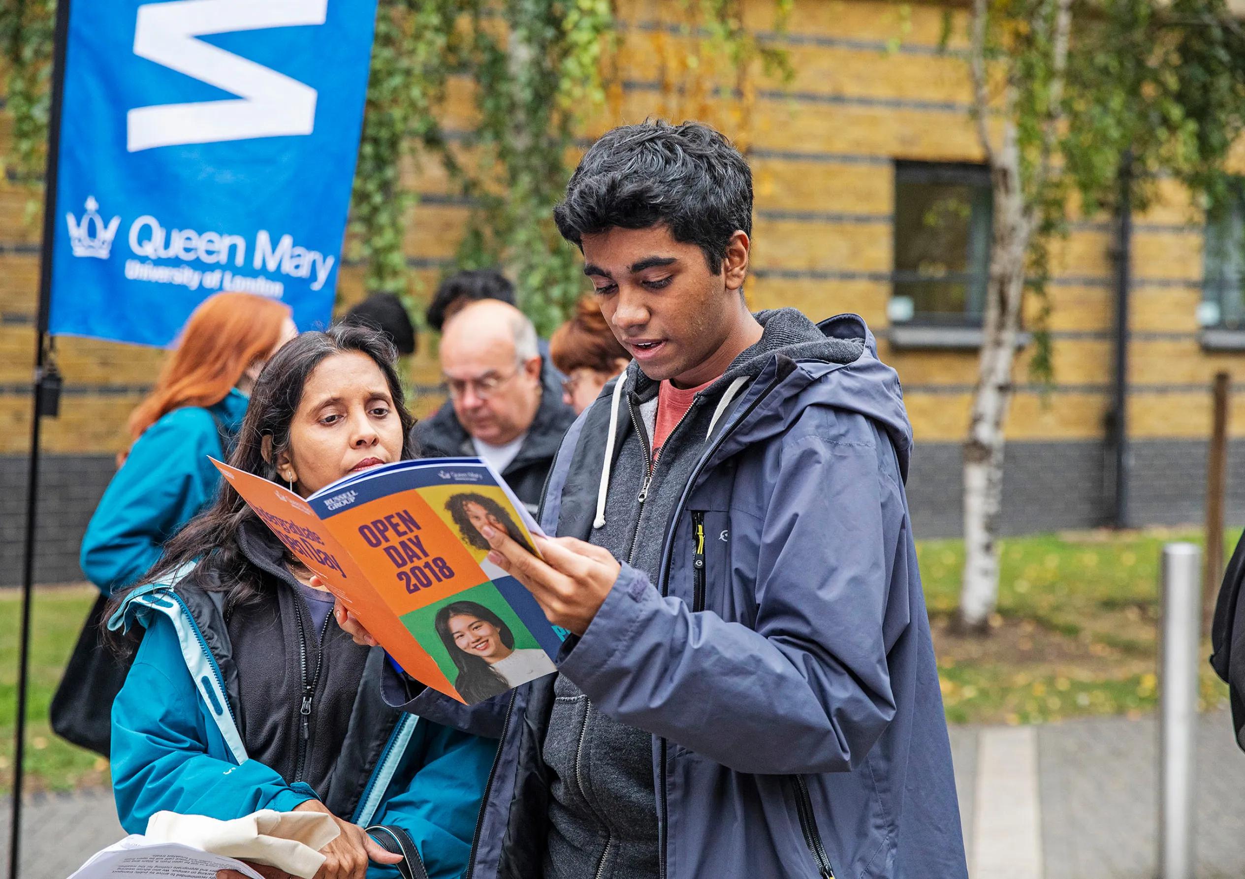 A man and woman looking at the brochure