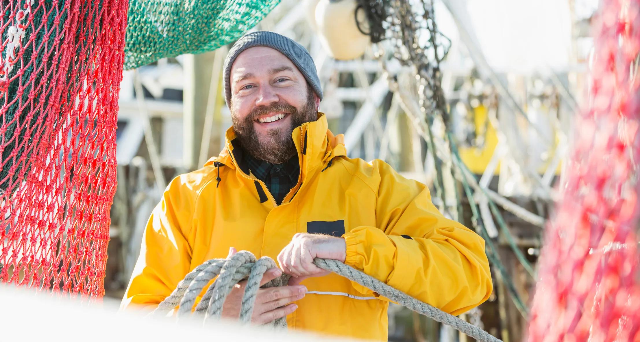 sailor fishing and smiling at the camera